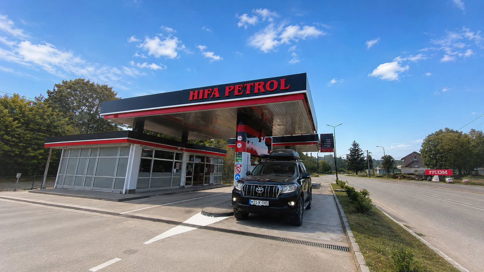 Crni terenac parkiran ispod nadstrešnice benzinske pumpe pored magistrale u Bosni i Hercegovini