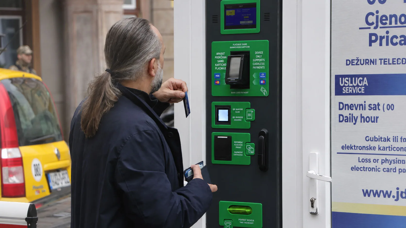 Vozač umeće bankovnu karticu u automat za bezgotovinsko plaćanje parkinga u centru Sarajeva