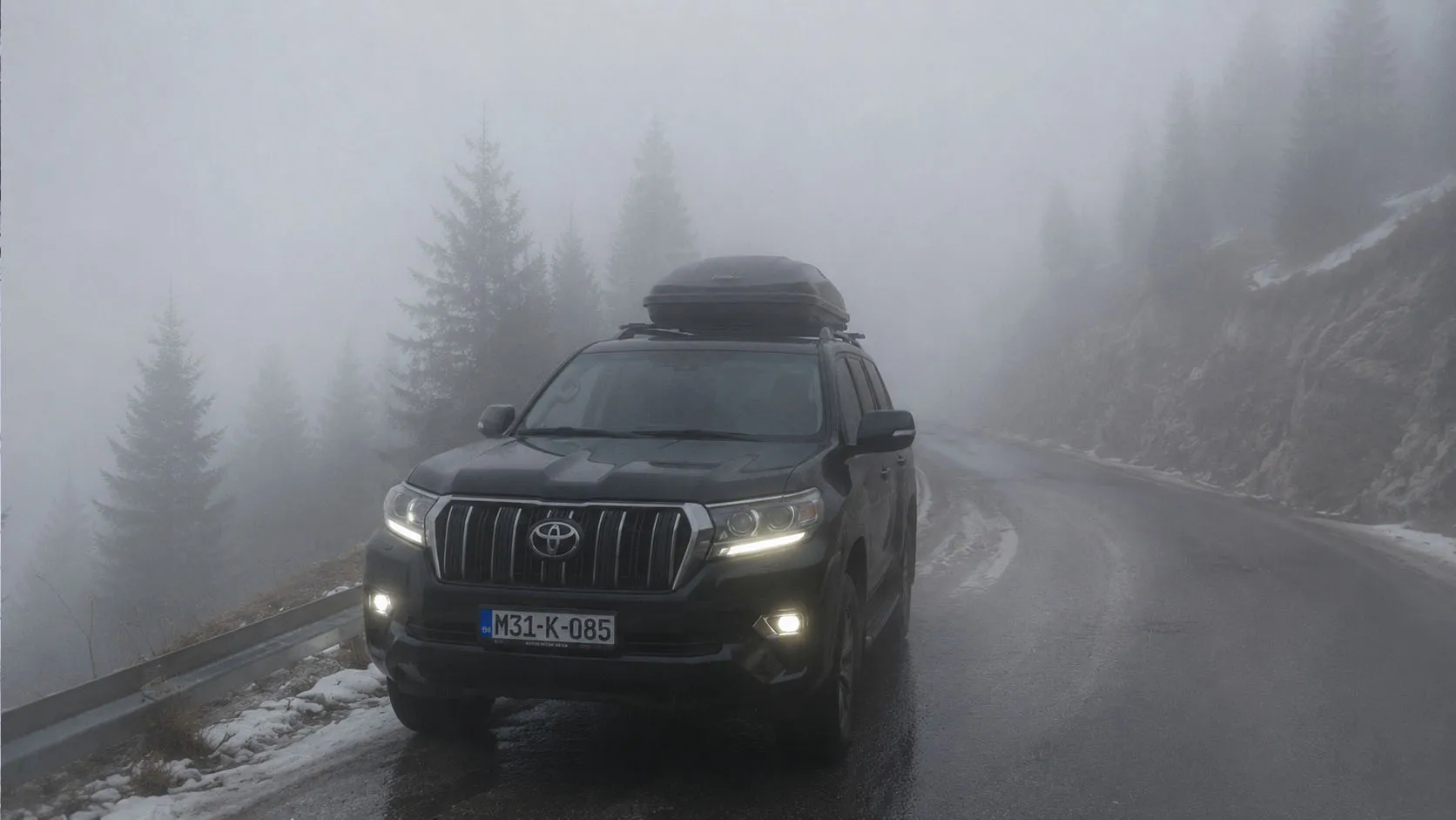 Automobil u gustoj magli i niskim oblacima na planinskoj cesti